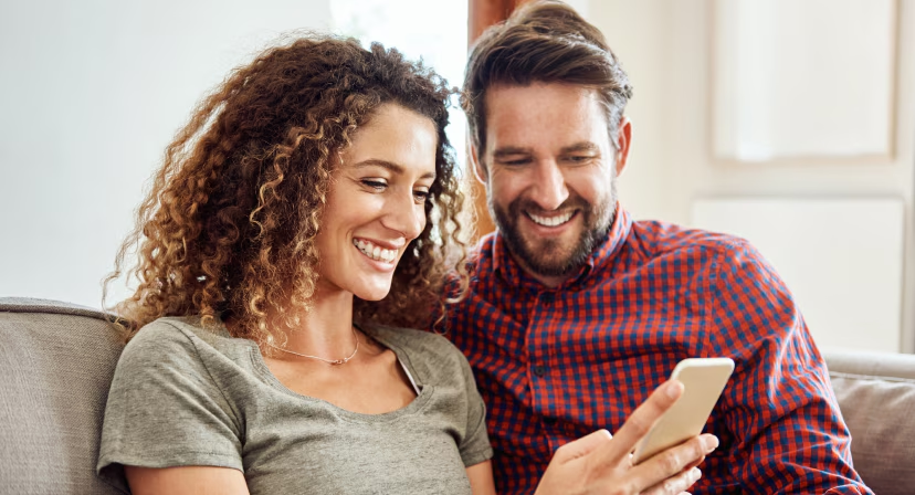 A man and a woman looking at their smartphone shopping the Shoppers Drug Mart Friends & Family Sale